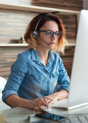 Woman working from home and using OfficeAlly wireless headset- Work from home headsets, office headsets